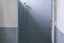 07 The bathroom is grey amd whoite, with long and thin tiles and a terrazzo floor