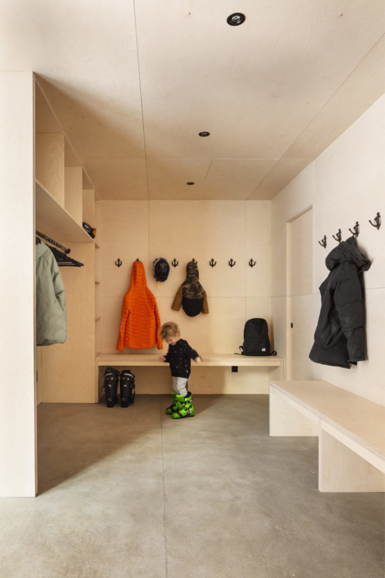 The mudroom is clad with light-colored plywood, all the furniture is made of the same plywood