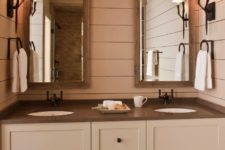 08 The bathroom is done in neutrals, with dark countertops and mirrors in wooden frames