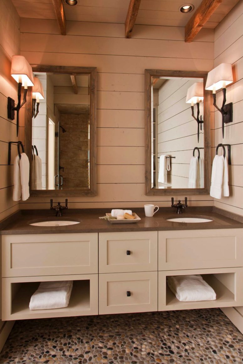 The bathroom is done in neutrals, with dark countertops and mirrors in wooden frames