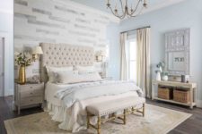 08 The bedroom is elegant and refined, with an accent wall, chic furniture and an ornate mirror