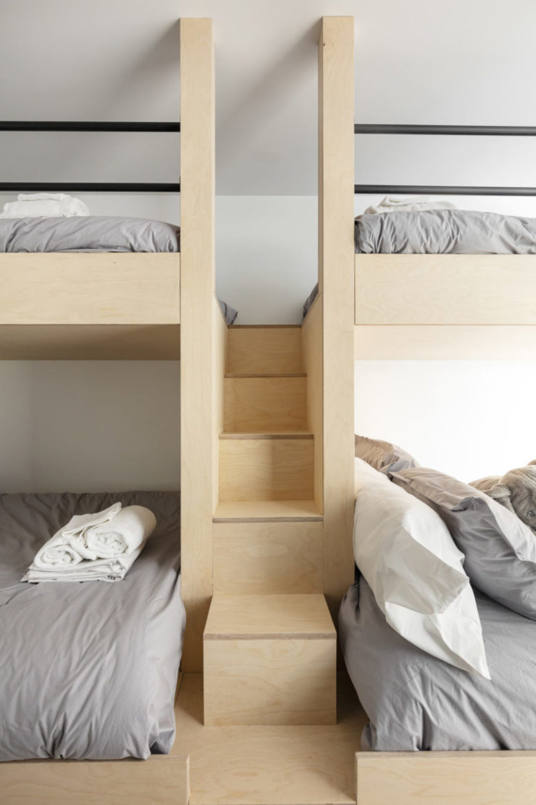 The guest bedroom features four bunk beds, everything is clad with light-colored plywood, too
