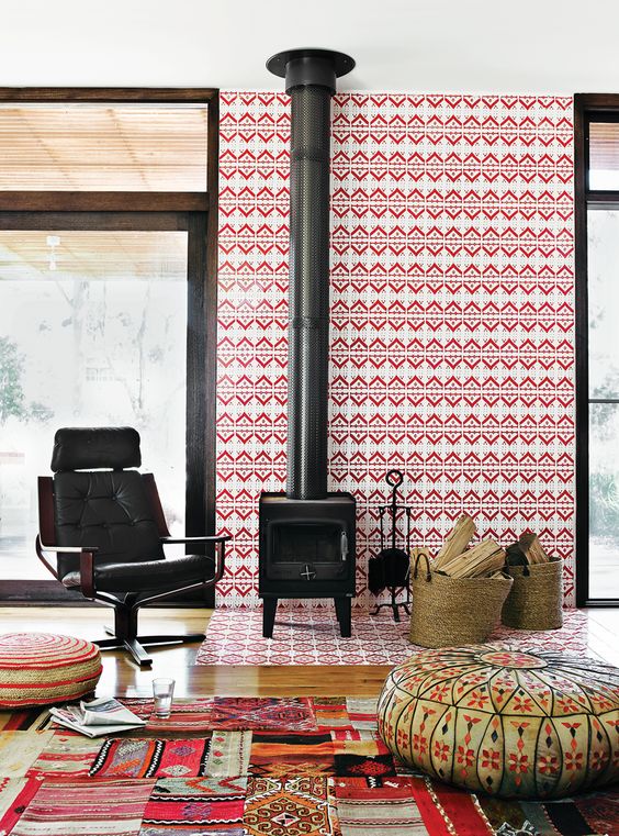 A bold mid century modern space with a wood burning stove, a bright tiled wall and colorful rugs