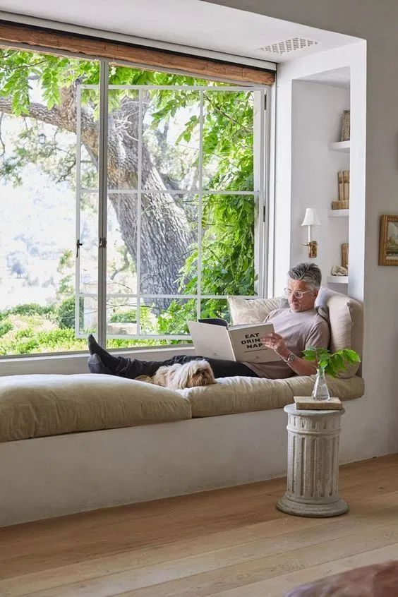 a windowsill daybed and bbuilt-in bookshelves on each side to turn this space into a functional reading nook