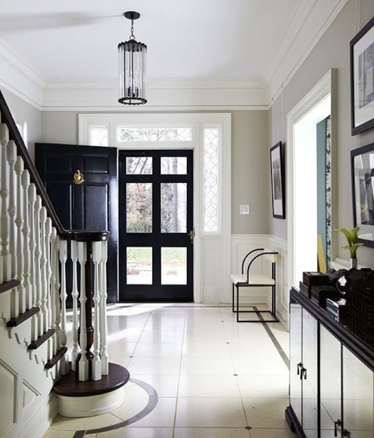 black interior doors echo with other black touches here - steps, a credenza and a bench in black and white