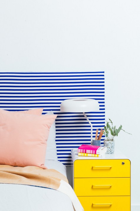an IKEA Ryggestad table top turned into a colorful headboard with striped fabric