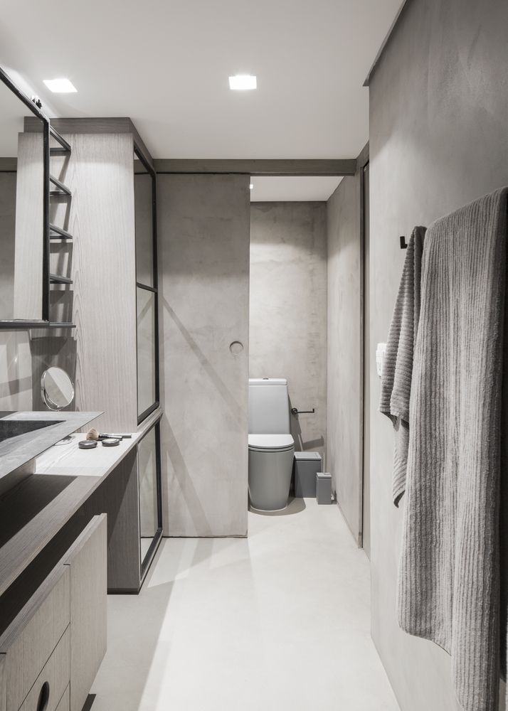 The second bathroom is neutral, fully done in sleek plywood, with mirrors and sliding doors