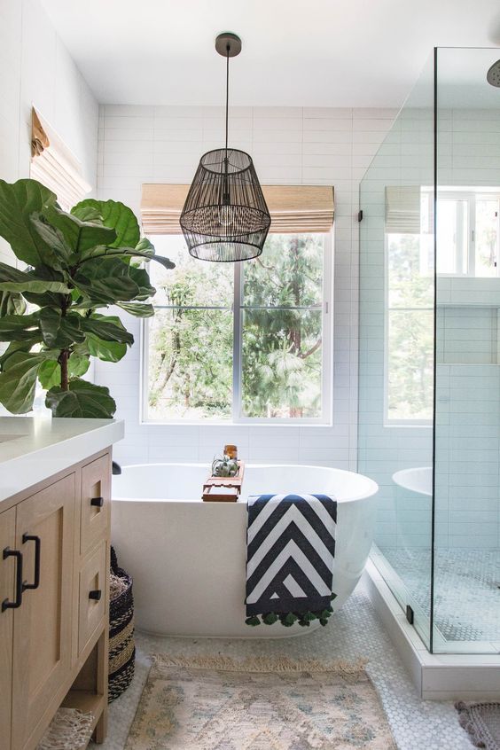 a printed rug and a catchy striped towel make the bathroom feel more californian together with an indoor tree