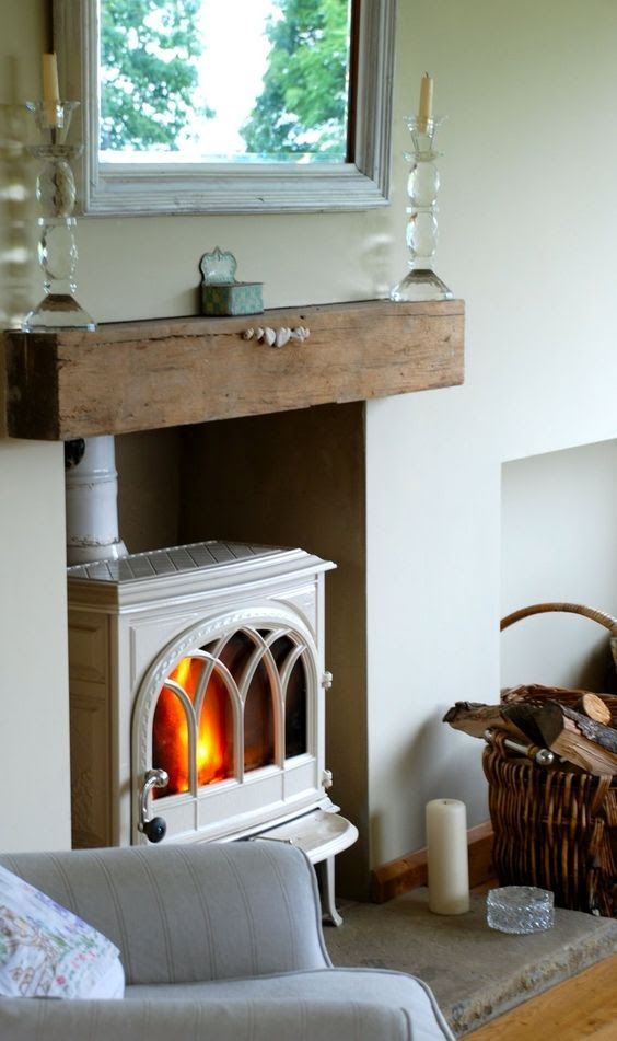 a vintage white wood-burning stove placed into a niche and with a mantel to remind of a classic stove