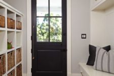 18 a black door echoes with a striped rug and throws of the mudroom adding a chic and bold touch to the space