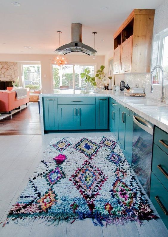 a bright printed rug and blue cabinets work well together giving the home a wild feel