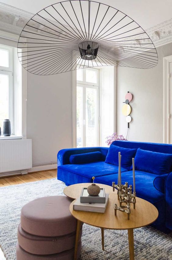 a luxurious living room with a cobalt blue velvet sofa that is the main centerpiece in the room