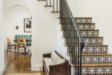 a Spanish-inspired space with printed tiles on stairs, wooden furniture and floors and wrought railing