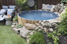 a boho outdoor space with planted greenery, boho decor, printed blue textiles and a small round pool clad with bamboo