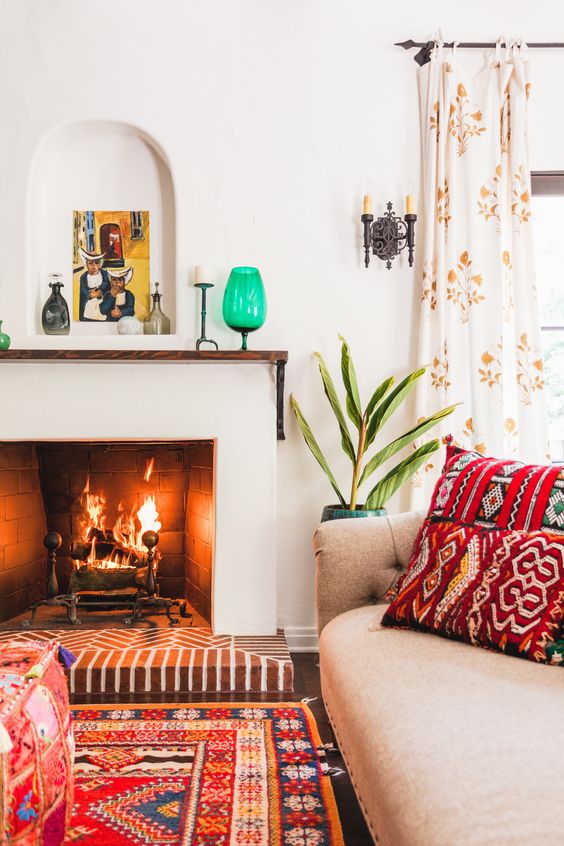a bright modern Spanish space with colorful printed textiles, bright touches, white walls and a fireplace, potted plants