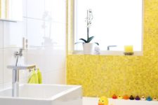 a colorful and fun kids’ bathroom in bright yellow and white, some bright accessories and colorful ducks
