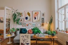 a colorful boho meets mid-century living room with a bright gallery wall, a printed rug and colorful pillows plus greenery