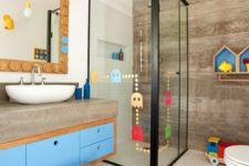 a contemporary kids’ bathroom with a colorful vanity, bright shelves, a colorful rug, colorful decals on the shower