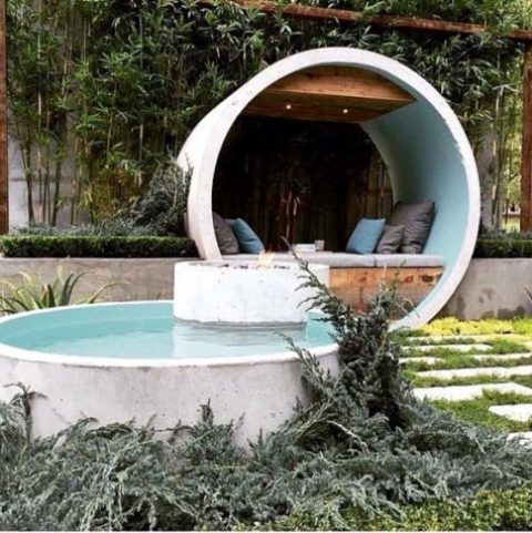a contemporary outdoor space with a terrace placed inside a white concrete circle and a matching pool