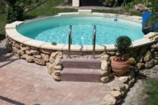 a large round pool clad with tiles and stone and with a brick deck next to it is a traditional otudoor feature to try