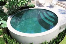 a minimalist round pool with steps surroundded with succulents and with a stone terrace and butterfly chairs
