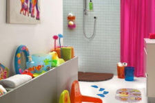 a modern kids’ bathroom with bright stools, artworks, toys, towels, accessories for fun