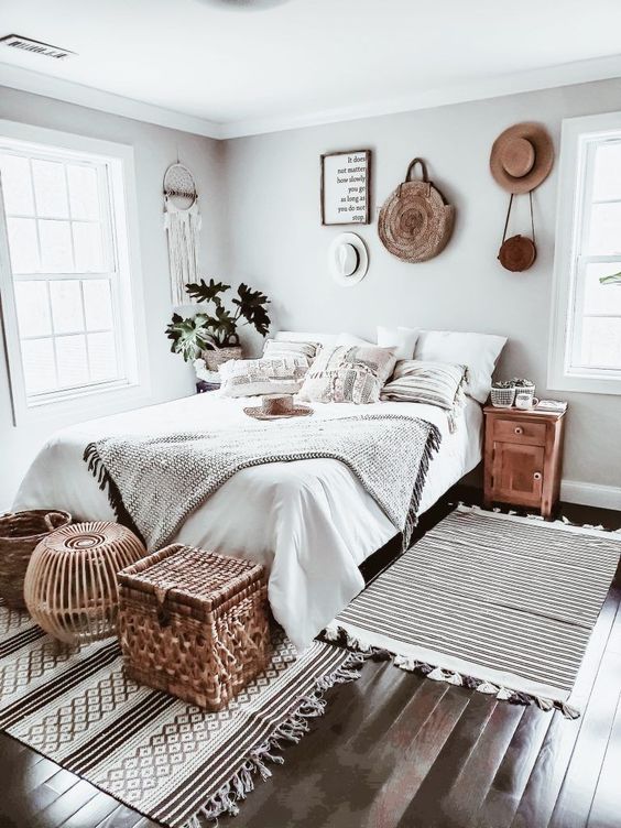 a neutral boho bedroom with layered crochet textiles, woven and wicker details, a dream catcher on the wall