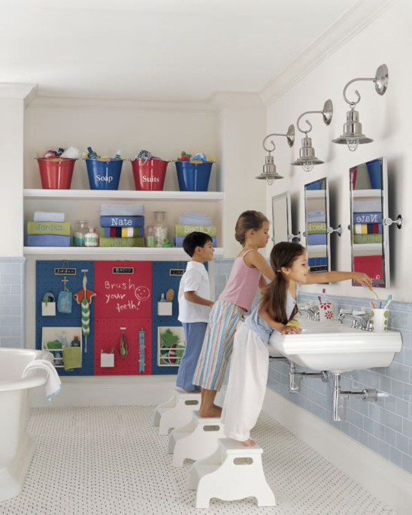 a neutral kids' bathroom with blue and red touches, accessories and a storage board for everyone