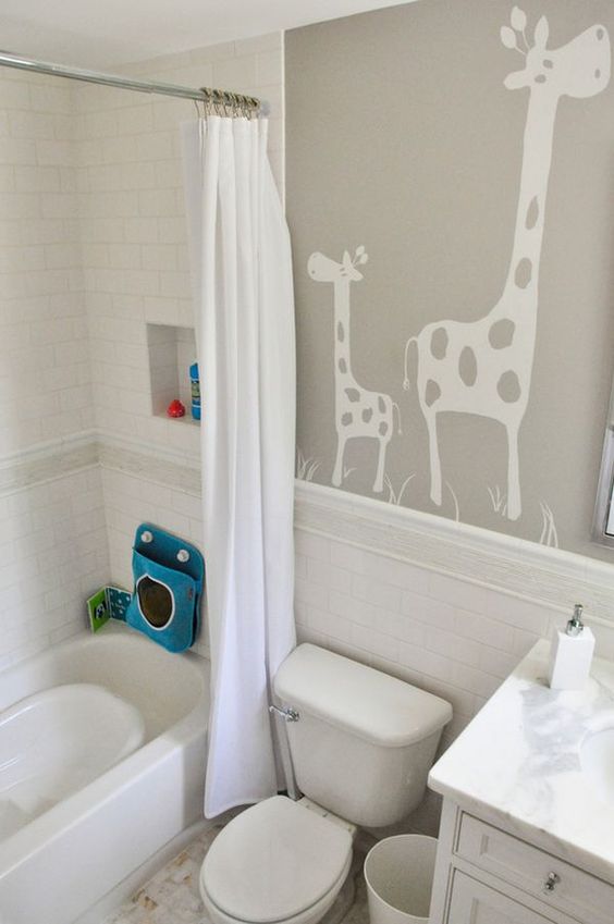 a neutral kids' bathroom with giraffes on the wall, some colorful touches and all neutral everything