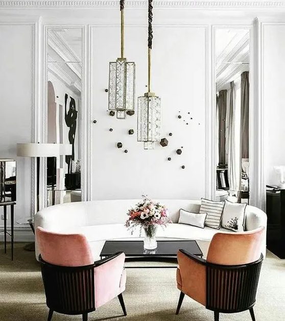 a refined white sofa with a curved silhouette, peachy curved chairs, unique pendant lamps and wall decor for a sophisticated space