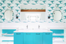 a sea-inspired kids’ bathroom with funny fish wallpaper, a bright blue vanity and open shelving