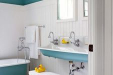 a serene kids’ bathroom in blue, white and yellow, with color block walls and bright touches