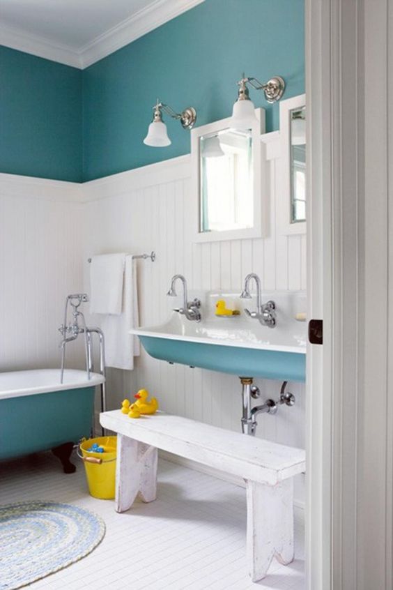 a serene kids' bathroom in blue, white and yellow, with color block walls and bright touches