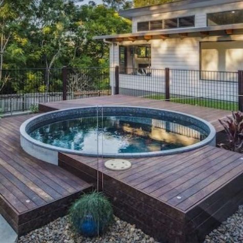 a small wooden deck with a round plunge pool that look very welcoming and stylish together
