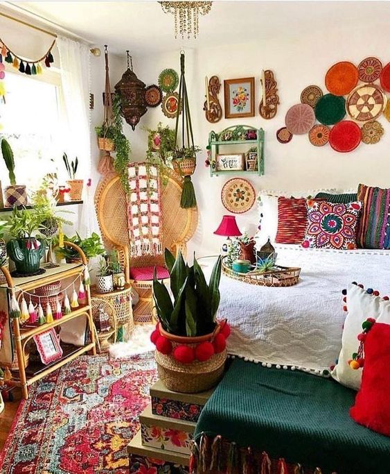 a super colorful boho bedroom with decorative plates, potted plants, colorful tassels and throws plus pompoms for decor