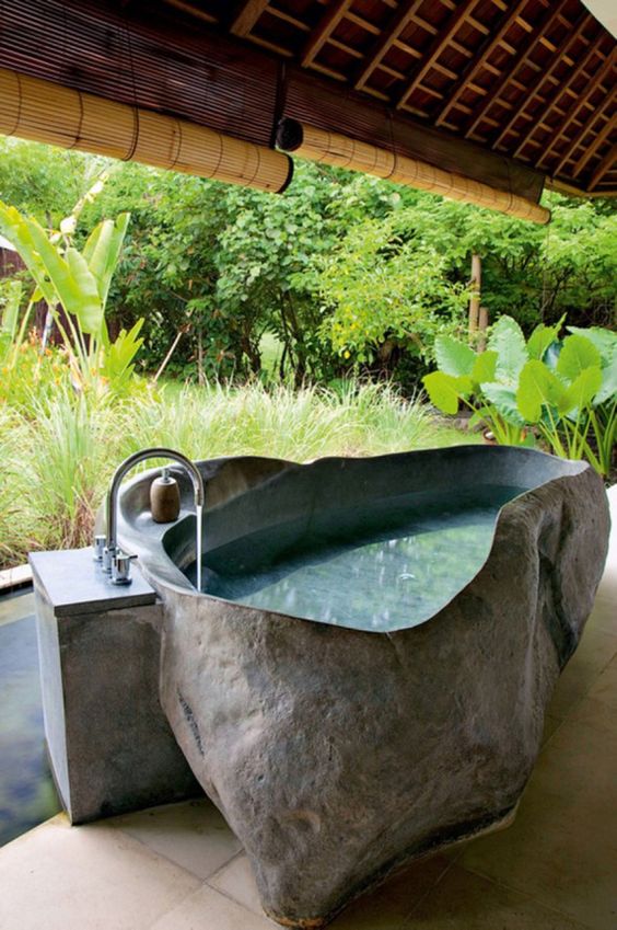 an outdoor stone bathtub with uneven edges will keep you cool outside durign hot days