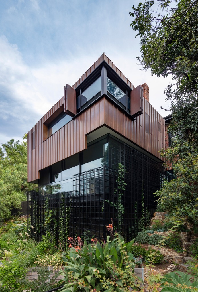 This contemporary home is built to resemble a tree house and it features a trellis for greenery to climb up it