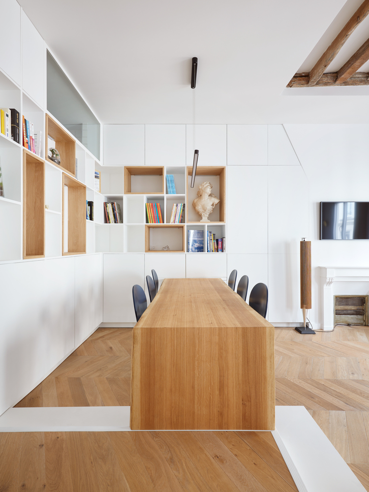 There are lots of storage units, open and closed sleek ones, and the dining table is a single and long slab of wood