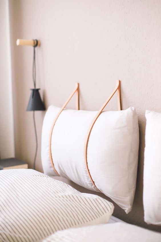 make a hanging headboard yourself hanging soem soft pillows on leather cords to secure them right