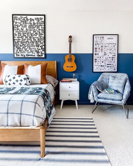 a small bedroom done with blueberry blue color blocking, graphic artworks and pritned textiles all over
