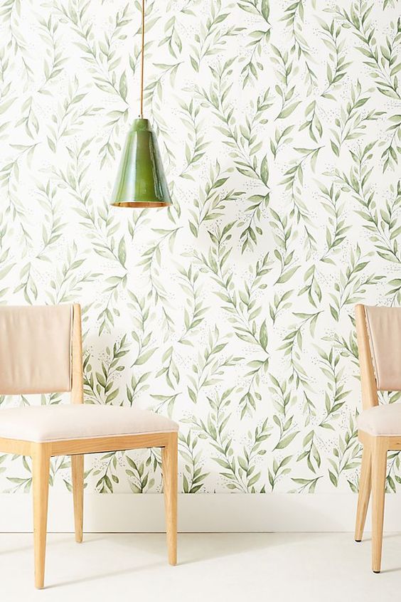 classic botanical wallpaper with a retro feel and a matching green porcelain lamp create a welcoming and cool space