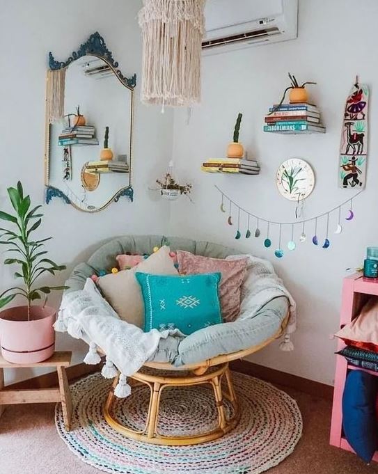 a colorful boho nook with a papasan chair with pastel pillows, a macrame chandelier and potted greenery and bright touches