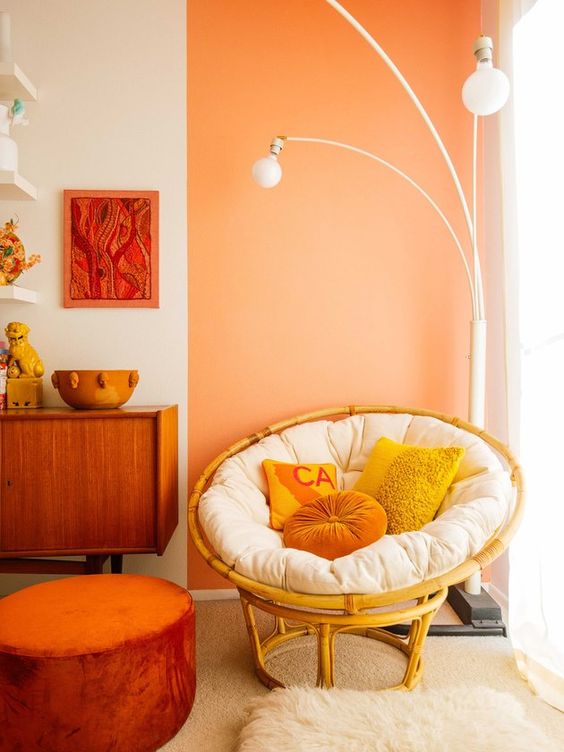 a bright space with a yellow papasan chair with a white futon and bright pillows plus a catchy floor lamp over it
