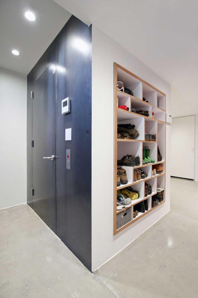 The mudroom features a creative shoe storage unit built into the wall