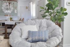 08 a dark wooden papasan chair with a neutral and pastel futon and pillows for a farmhouse space
