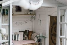 08 a small garden shed repurposed into a small bedroom with a pallet bed and pastel linens