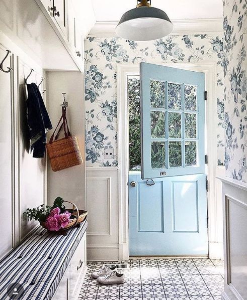 A vintage inspired entryway with blue floral wallpaper and elegant wainscoting looks very chic and inviting