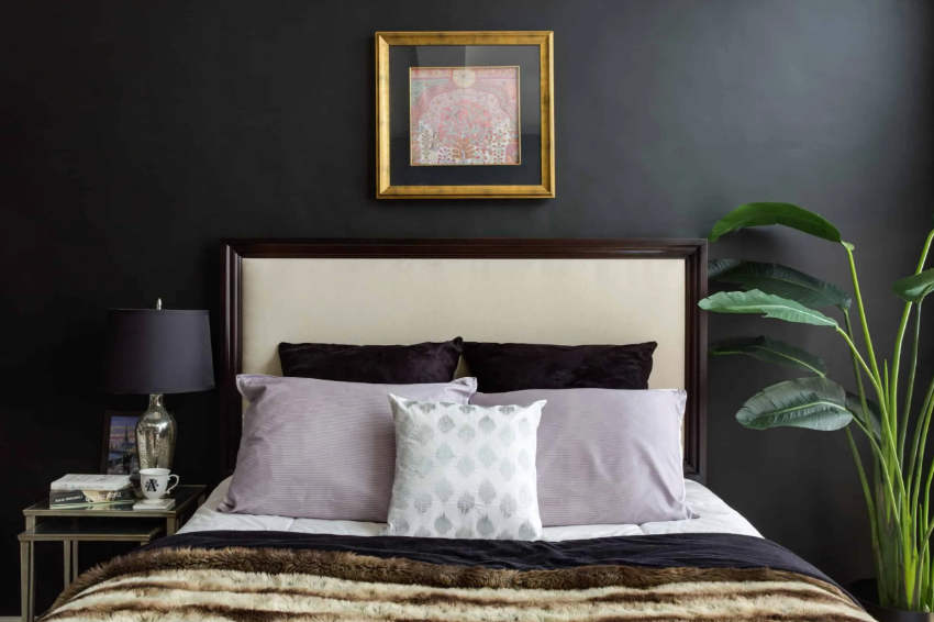 A small bedroom with onyx colored walls and a matching lamp to make it bold and with a character