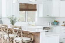 09 a white farmhouse kitchen with a kitchen island that features a raised countertop for eating here