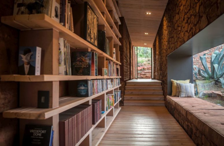 A corridor is used to create a reading space - one wlal is taken by a large bookshelf and there's a windowsill reading space in here